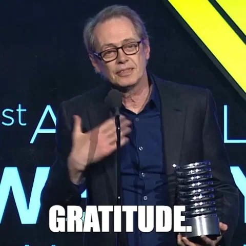 Reaction GIF. Steve Buscemi on stage with an award saying "gratitude".