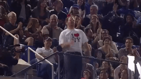 Desconhecido fazendo dancinha em estádio com camiseta I love New York.