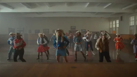 Danseurs de country en jupes colorées dans une salle de bal