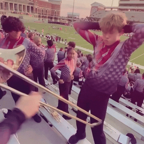 A marching band member in the stands doing their own thing