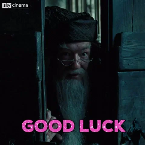 Un vieil homme avec une longue barbe grise regarde par une porte entrouverte, accompagné du texte "GOOD LUCK" en rose.
