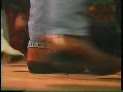 Gros plan sur des bottes de country en train de danser sur un parquet